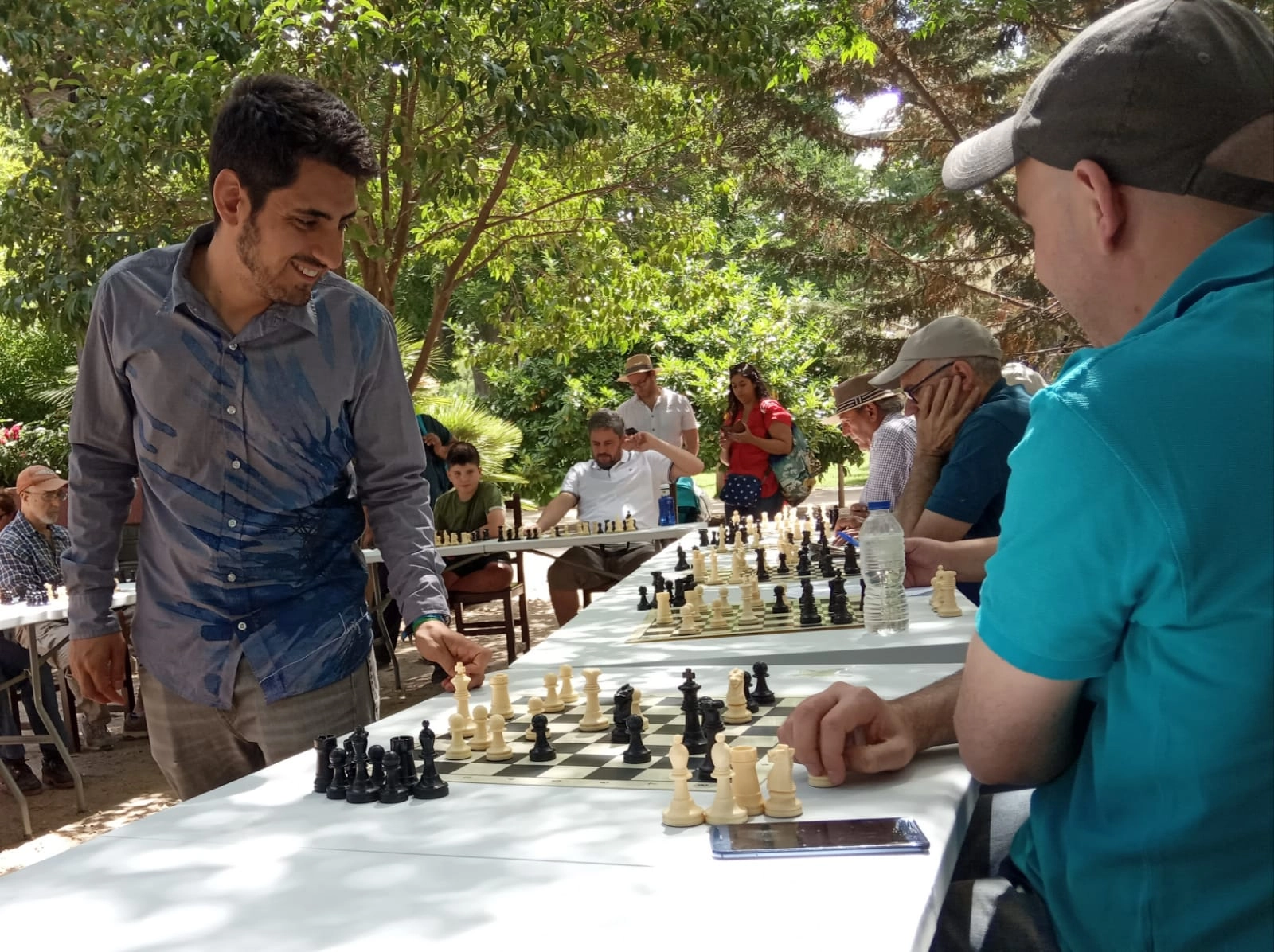 Un maestro de ajedrez dando partidas simultaneas a mas de 8 personas