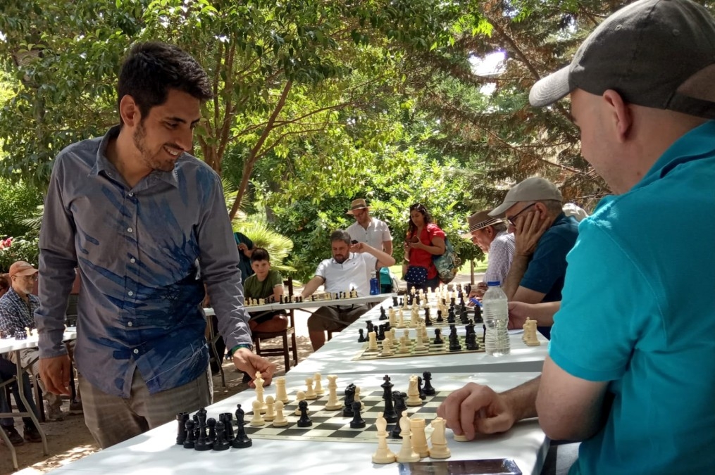Un maestro de ajedrez dando partidas simultaneas a mas de 8 personas